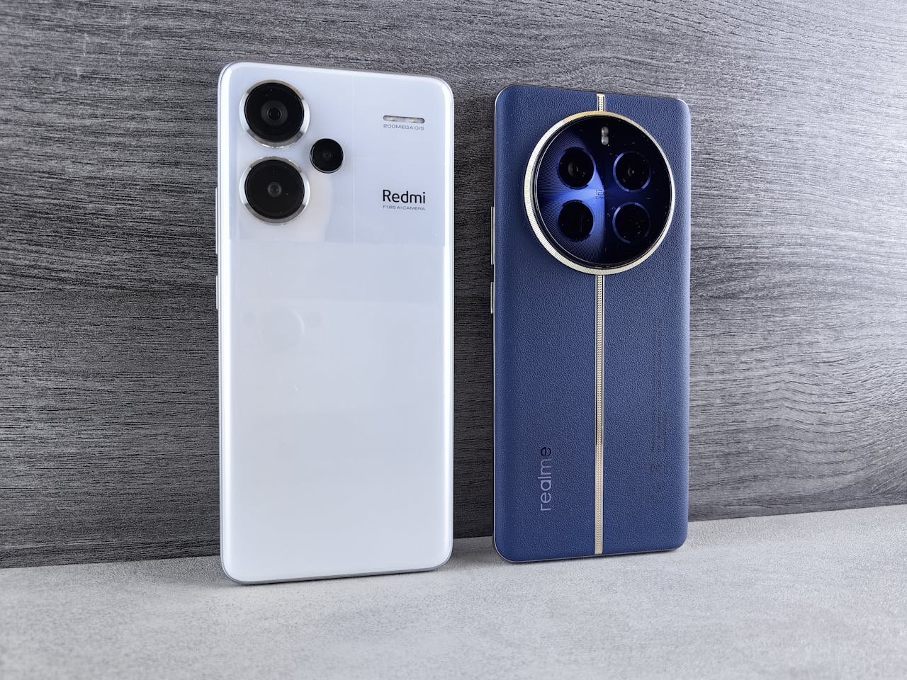 services-02 Two modern smartphones, one white and one blue, displayed vertically on a wooden surface.